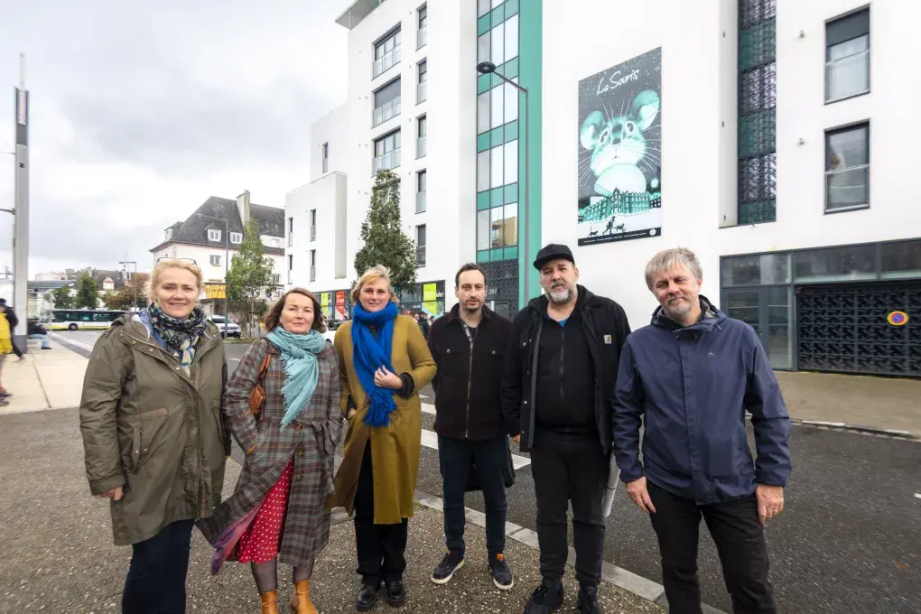 Plusieurs personnes devant un immeuble.