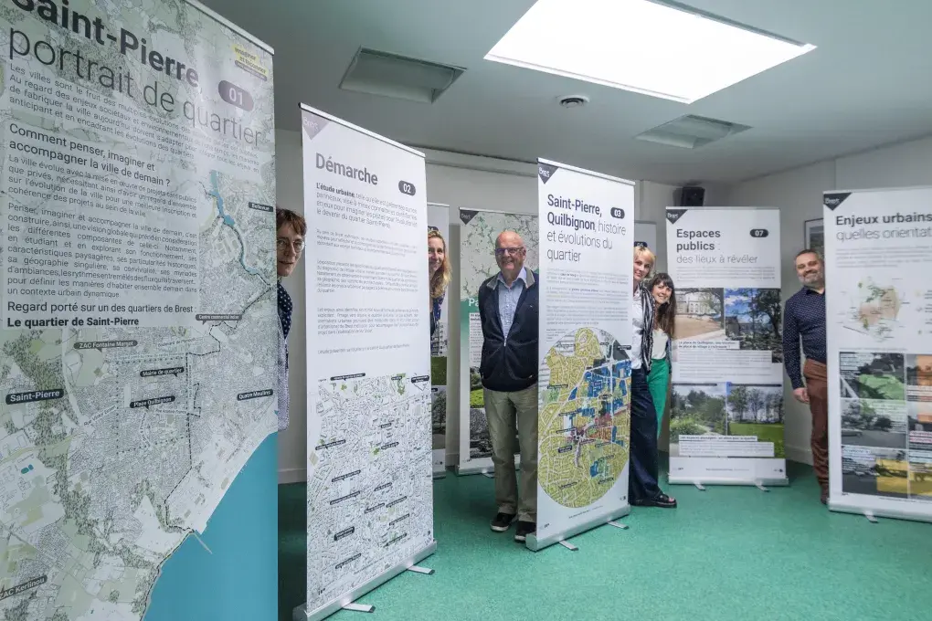 Plusieurs personnes posent avec de grandes affiches.