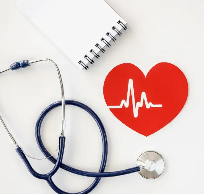 Un stéthoscope, avec un coeur dessiné et un carnet de notes