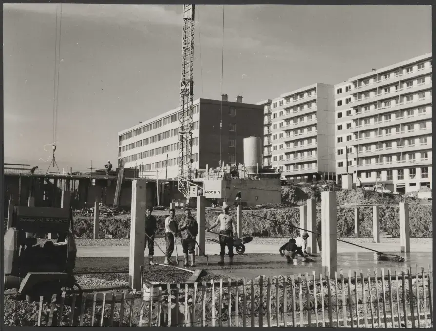Des ouvriers du bâtiment posant sur un chantier de construction d'immeuble