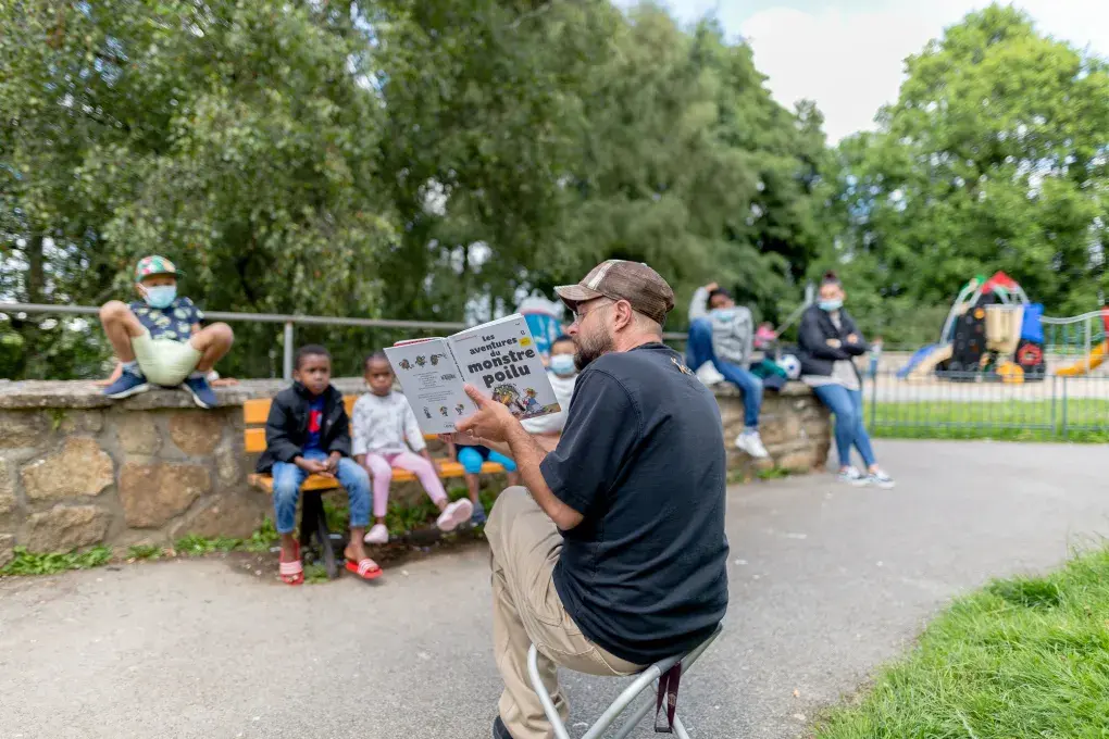 une personne qui lit un livre à des enfants dans un quartier de Brest