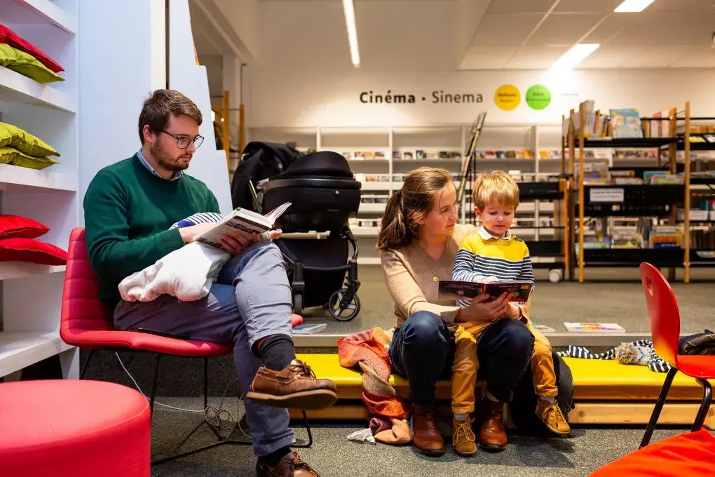 une famille qui lit à la bibliothèque