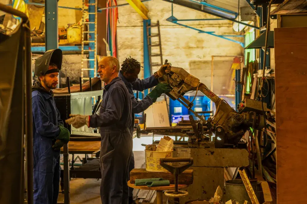 des personnes qui manipulent des machines dans un atelier industriel