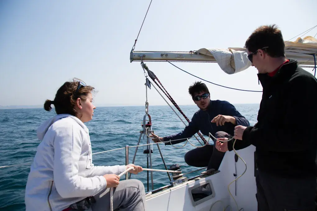 Une femme et deux hommes sur un voilier