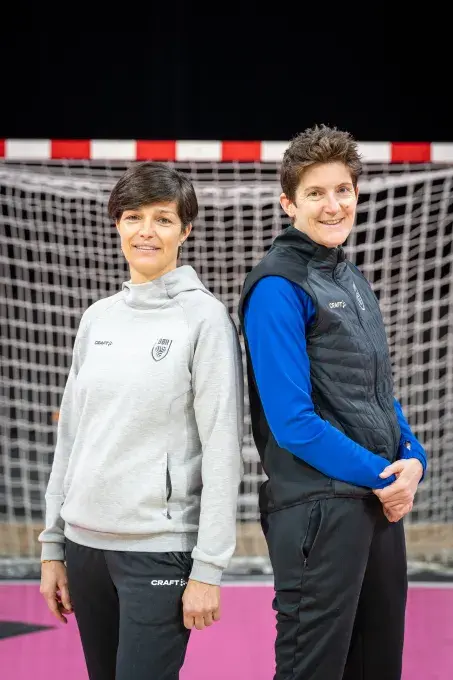Deux femmes l'une à côté de l'autre devant un but