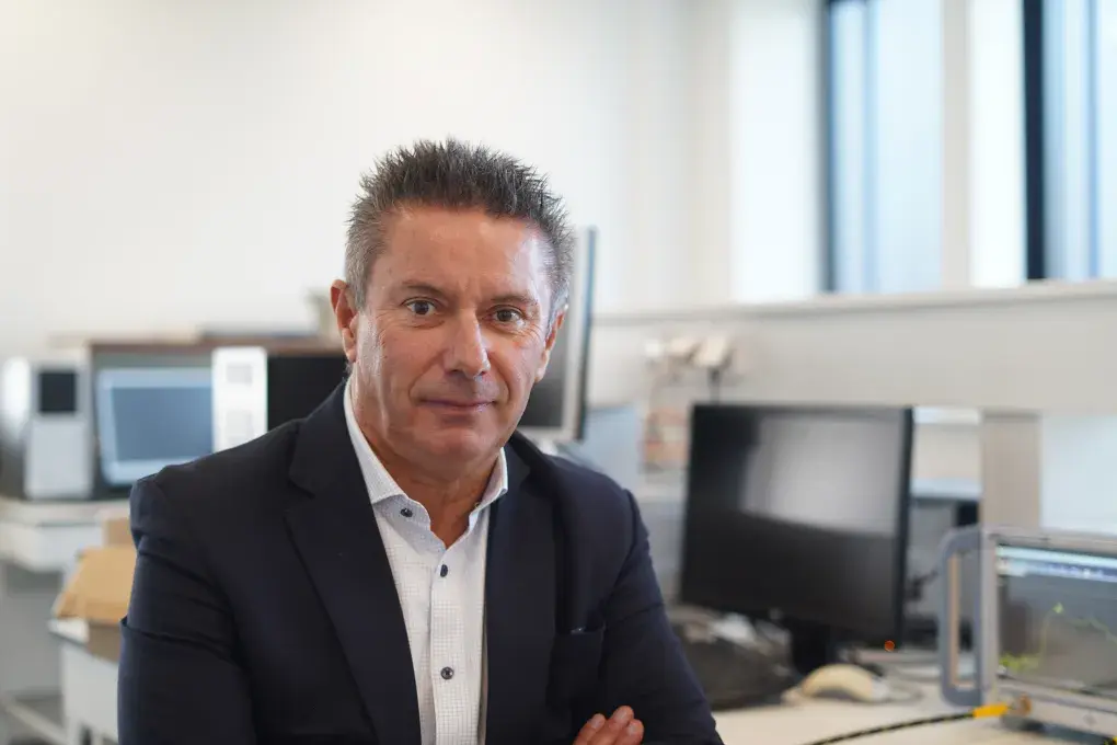 Un homme pose devant des ordinateurs