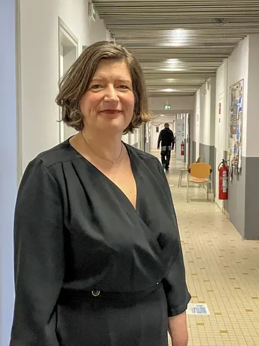 Une femme posant dans un couloir