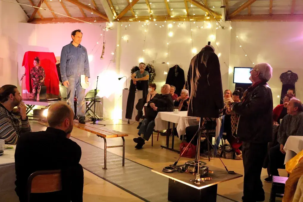 Un homme debout sur un banc et des personnes attablées tout autour