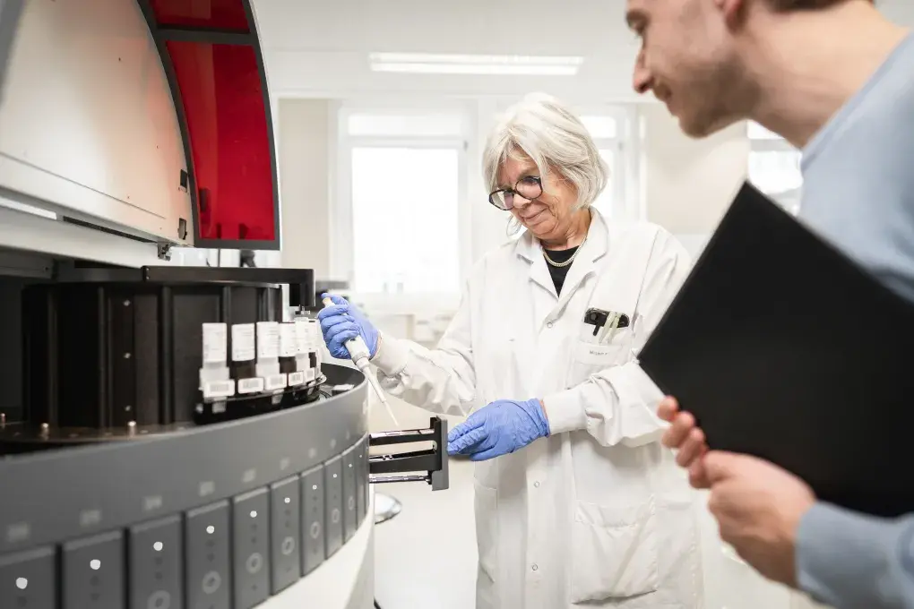 Une femme tenant une pipette et un homme tenant un dossier