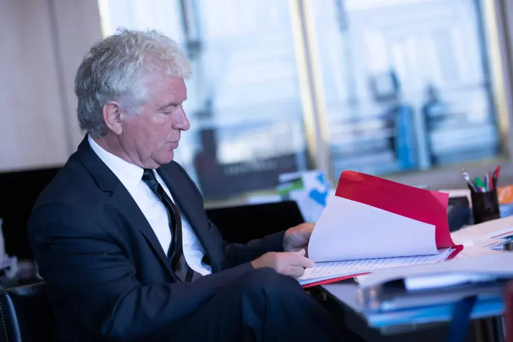 Un homme à son bureau ouvrant un dossier