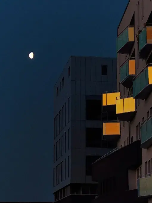 lune dans un ciel nocturne bleuté et des balcons qui reflètent la lumière