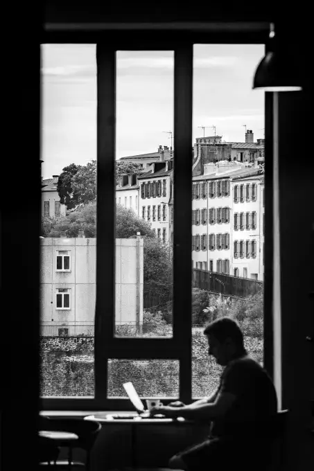 personne qui travaille devant une fenêtre