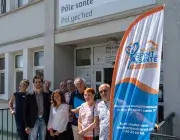 Plusieurs personnes posent devant un bâtiment.