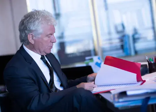 Un homme à son bureau ouvrant un dossier
