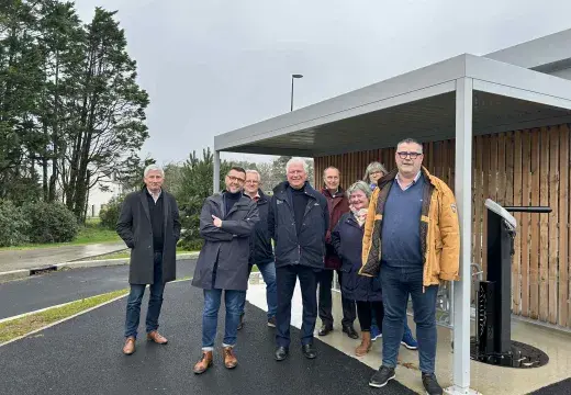 Un groupe de personnes debout devant un abri à vélo
