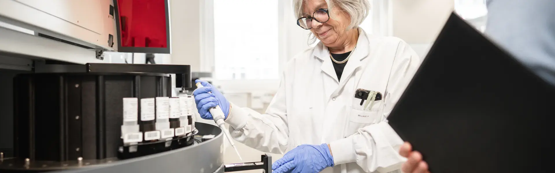 Une femme tenant une pipette et un homme tenant un dossier