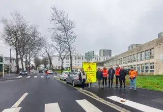 Plusieurs personnes posent dans une rue.