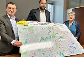 Deux hommes et une femme présentent le plan des travaux à Lambézellec. 